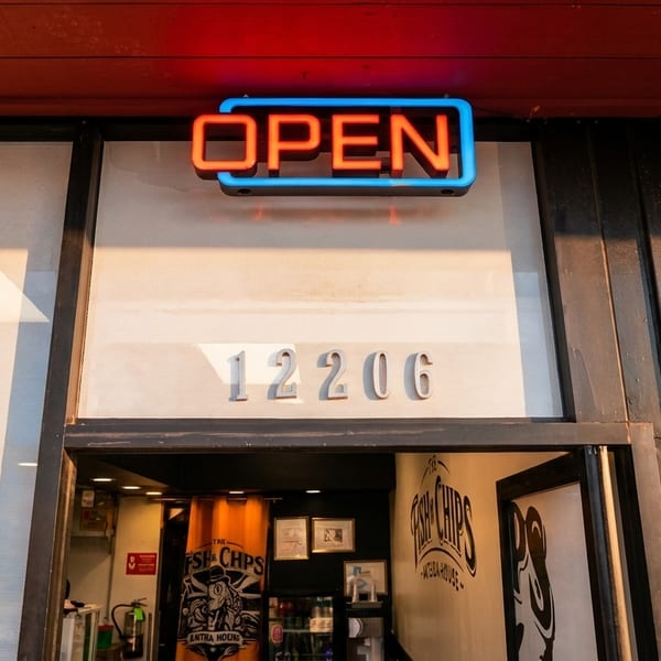 A neon "OPEN" sign glows above the entrance to a restaurant with the address 12206.